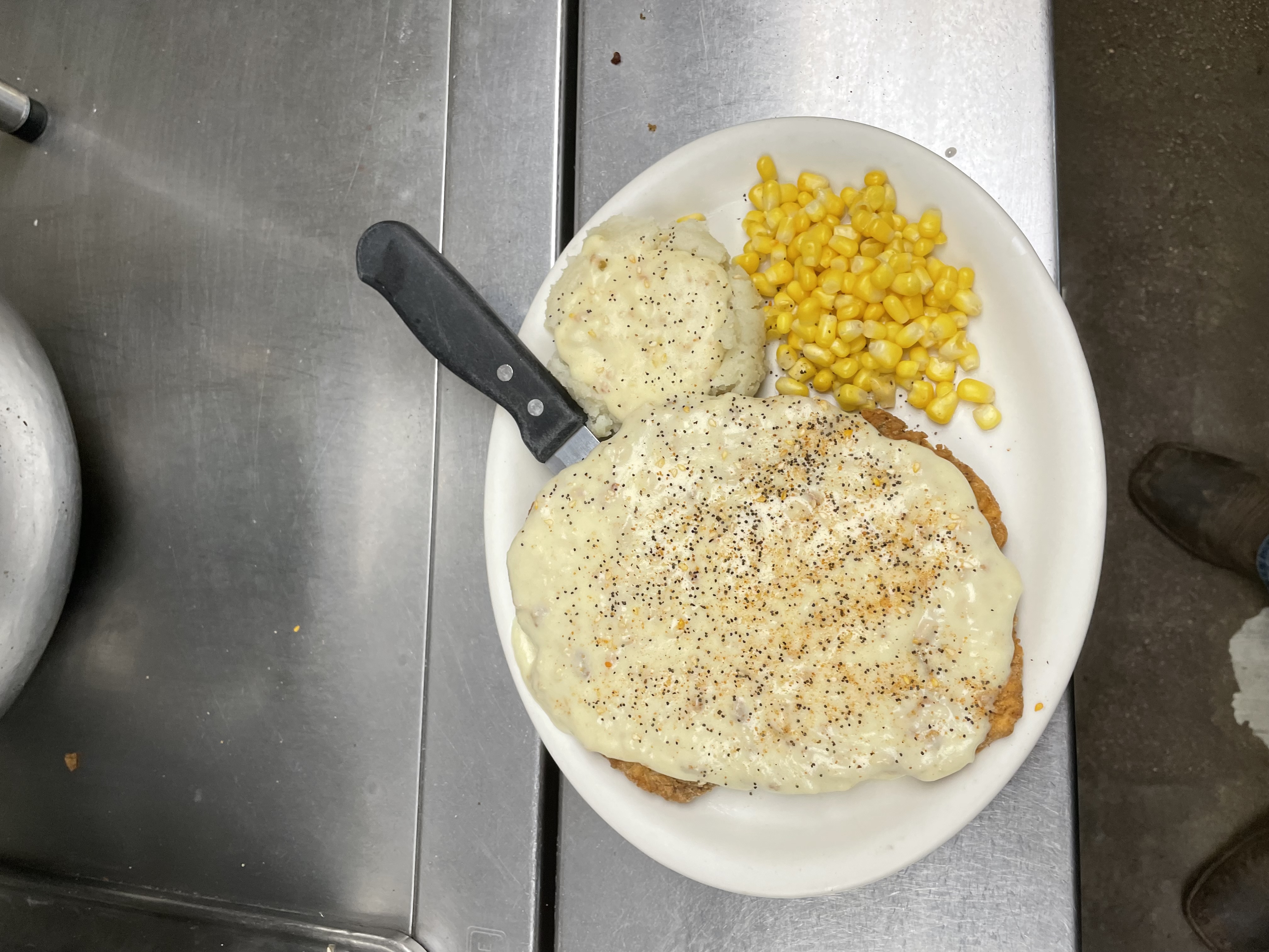 Chicken fried steak with white gravy and corn