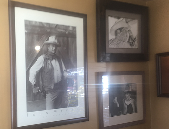 John Wayne and western art on the dining room wall